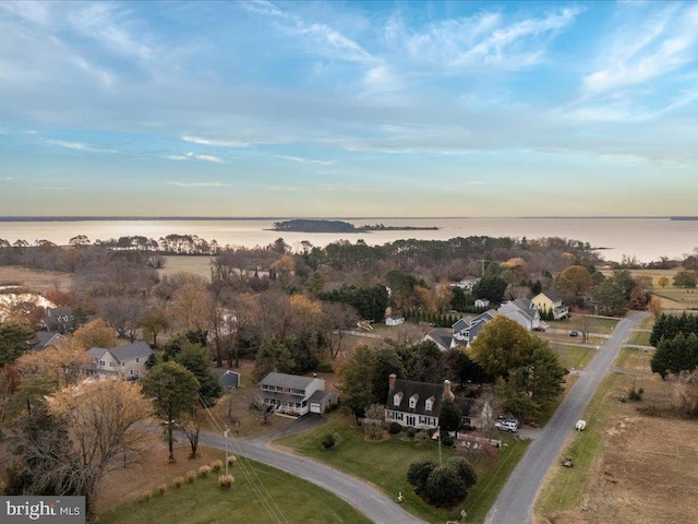 aerial view at dusk featuring a water view