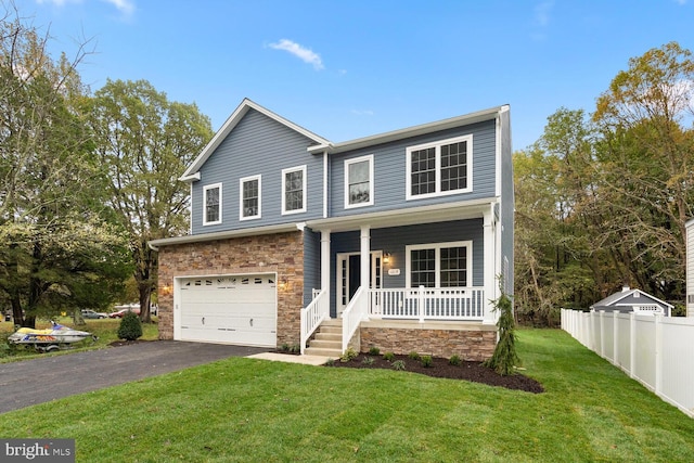 view of front of house featuring a porch, a front yard, and a garage