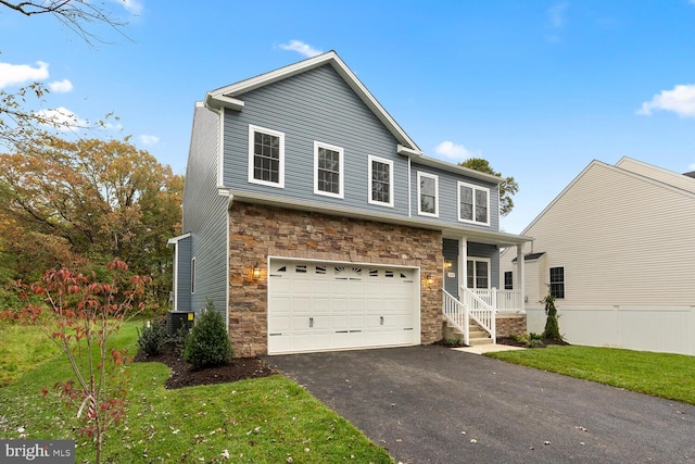 view of front of home featuring a garage, a front lawn, and central air condition unit