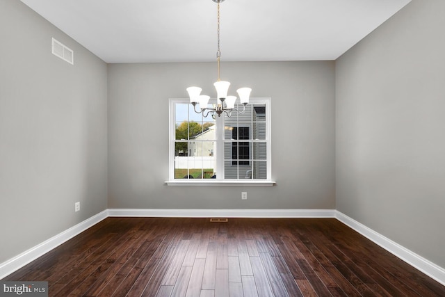 unfurnished dining area with a chandelier and dark hardwood / wood-style floors