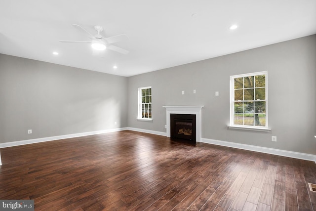 unfurnished living room featuring ceiling fan, dark hardwood / wood-style flooring, and a wealth of natural light