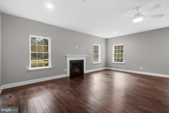 unfurnished living room with ceiling fan and dark hardwood / wood-style flooring