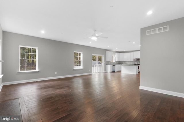 unfurnished living room featuring ceiling fan and dark hardwood / wood-style flooring