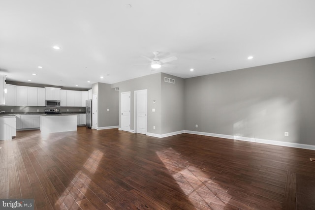 unfurnished living room featuring ceiling fan and hardwood / wood-style floors