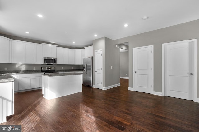 kitchen featuring white cabinetry, a center island, stainless steel appliances, and dark hardwood / wood-style floors