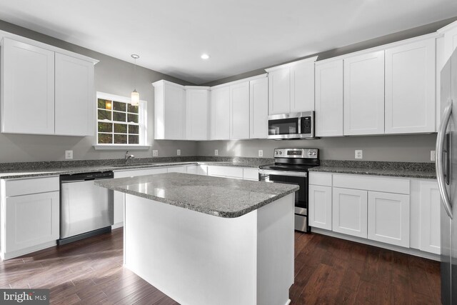 kitchen with white cabinets, dark hardwood / wood-style flooring, and stainless steel appliances