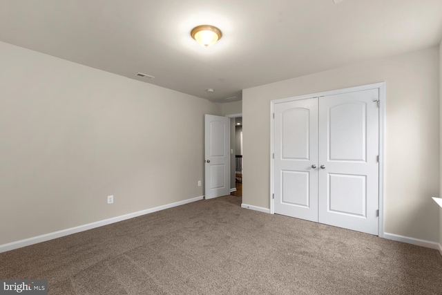 unfurnished bedroom featuring carpet flooring and a closet