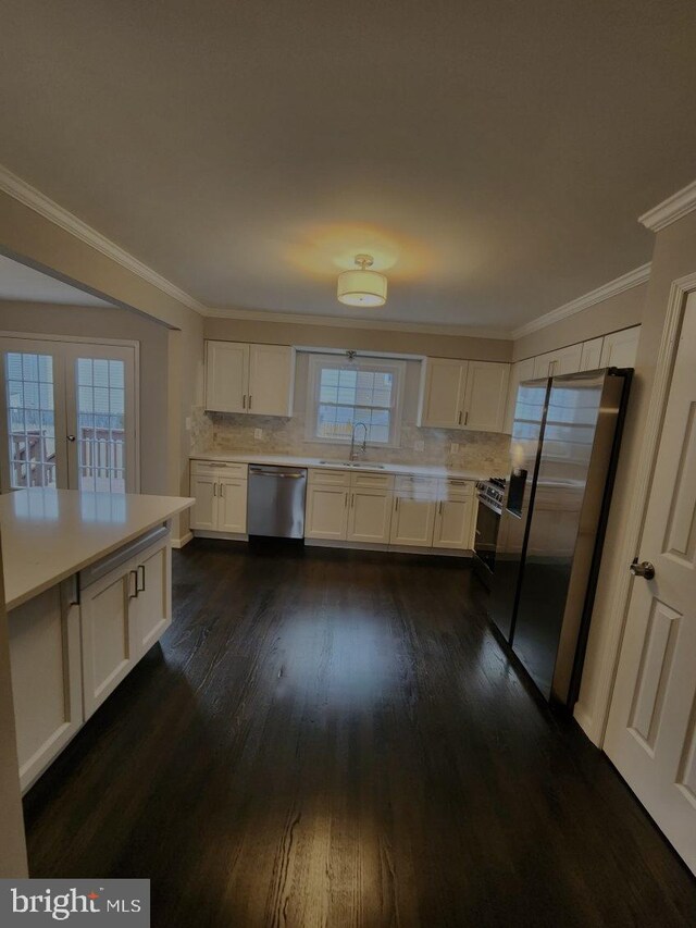 kitchen featuring a healthy amount of sunlight, white cabinetry, dark hardwood / wood-style flooring, and stainless steel appliances