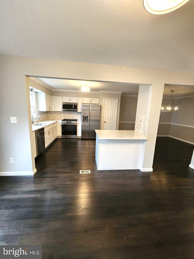 kitchen featuring white cabinets, sink, dark hardwood / wood-style flooring, kitchen peninsula, and stainless steel appliances