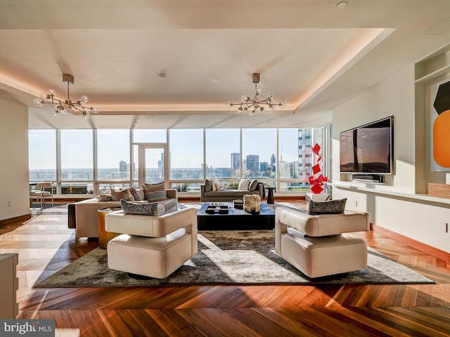 living room with a raised ceiling, parquet flooring, and a notable chandelier