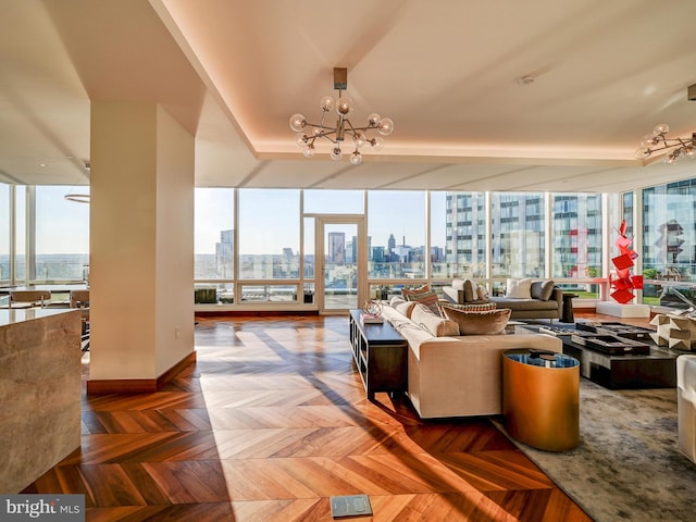 living room featuring a notable chandelier, parquet flooring, and a wealth of natural light