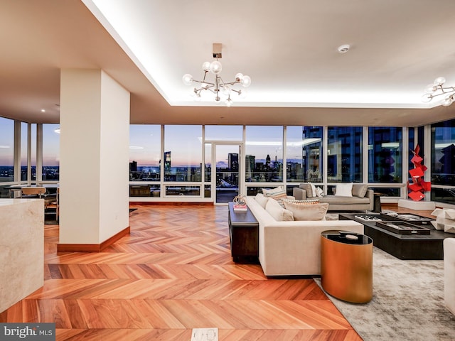 living room featuring floor to ceiling windows, parquet flooring, and a notable chandelier