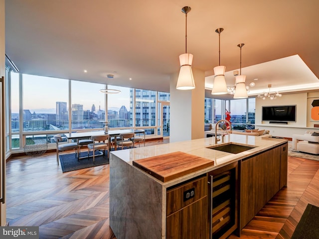 kitchen with a wealth of natural light, an island with sink, and wine cooler