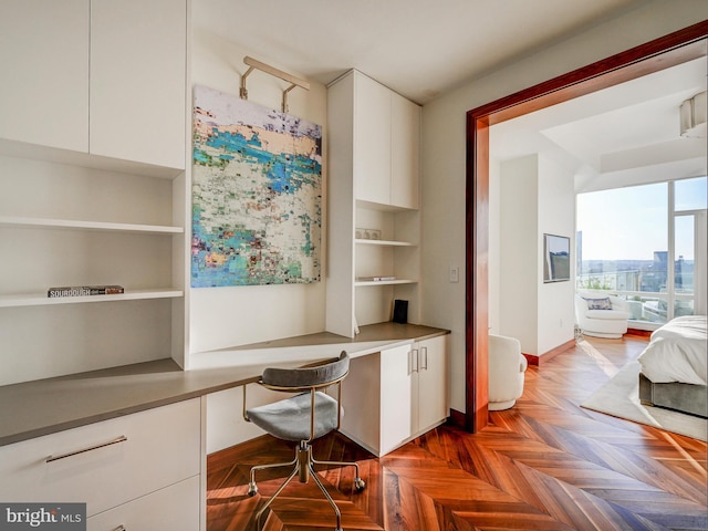 office featuring built in desk and parquet flooring