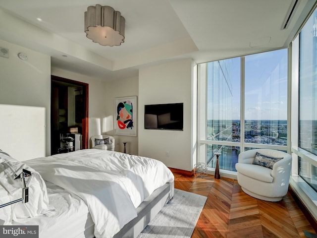 bedroom featuring a raised ceiling and parquet flooring