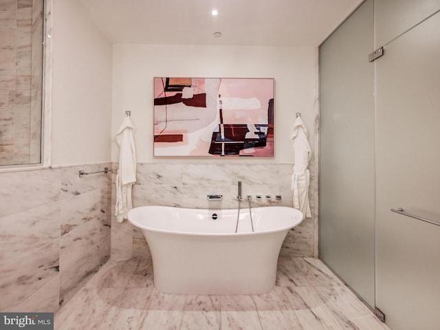 bathroom with separate shower and tub and tile walls