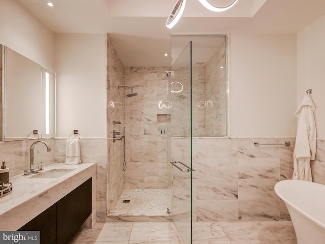 bathroom featuring vanity, separate shower and tub, and tile walls