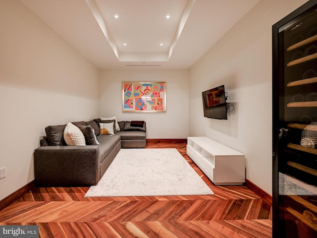 living room with a raised ceiling and parquet floors