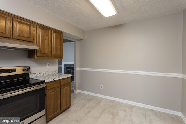 kitchen with light stone countertops, a textured ceiling, and electric range