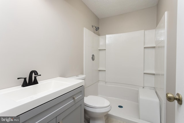 bathroom featuring a shower, vanity, a textured ceiling, and toilet