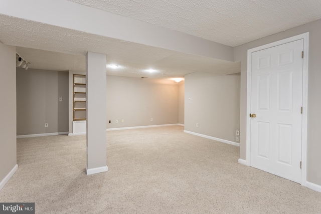 basement featuring light carpet and a textured ceiling