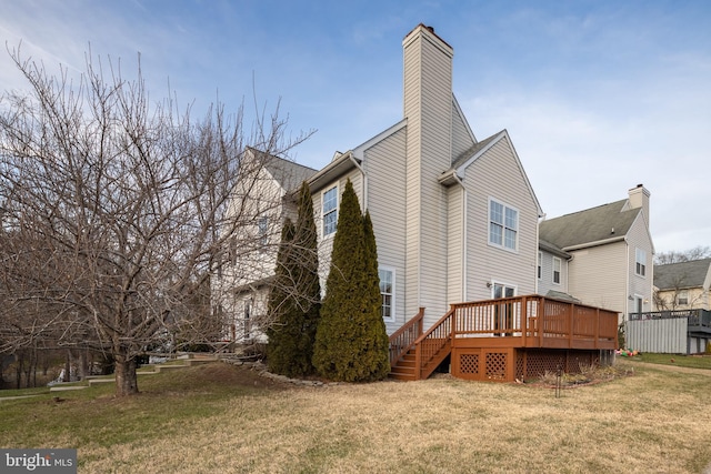 back of house featuring a lawn and a deck