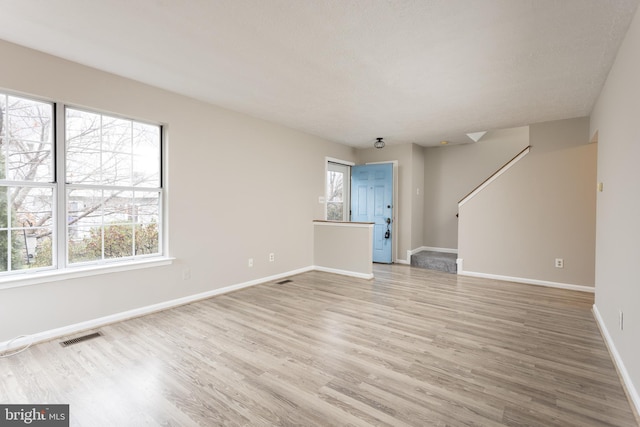 unfurnished living room featuring hardwood / wood-style flooring and a healthy amount of sunlight