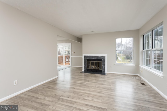 unfurnished living room featuring a fireplace and light wood-type flooring