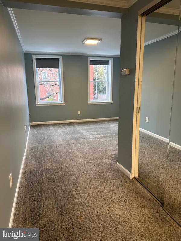 unfurnished room featuring carpet floors and crown molding