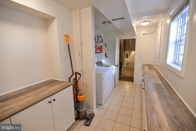 laundry room featuring light tile patterned flooring and washing machine and dryer