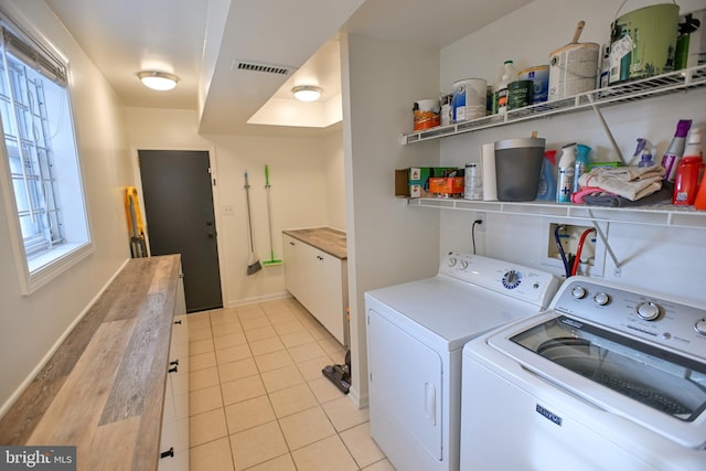 laundry room with independent washer and dryer and light tile patterned flooring