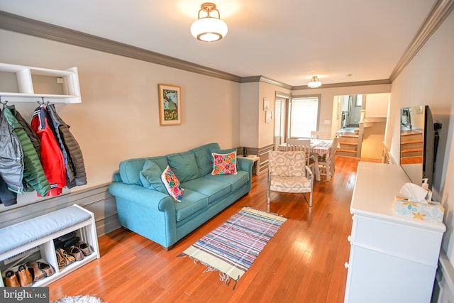 living room with wood-type flooring and ornamental molding