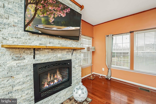 living room featuring a fireplace, hardwood / wood-style floors, and crown molding