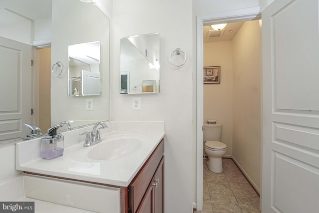 bathroom with tile patterned flooring, vanity, and toilet