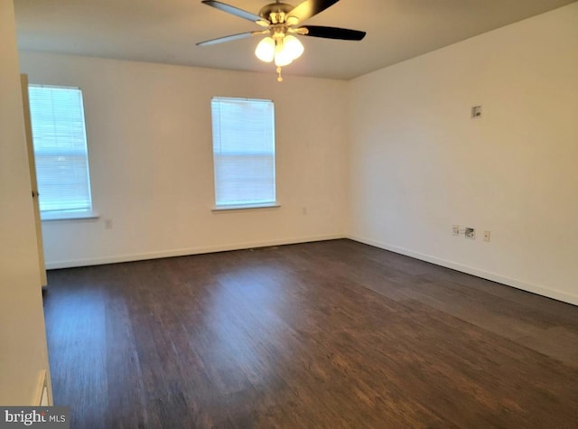 empty room with ceiling fan and dark wood-type flooring