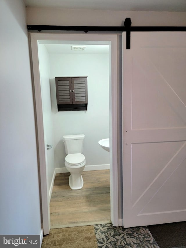 bathroom featuring wood-type flooring and toilet