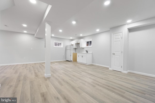 basement featuring light hardwood / wood-style floors and white refrigerator