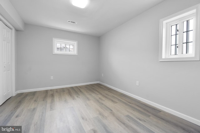 spare room featuring a wealth of natural light and light wood-type flooring