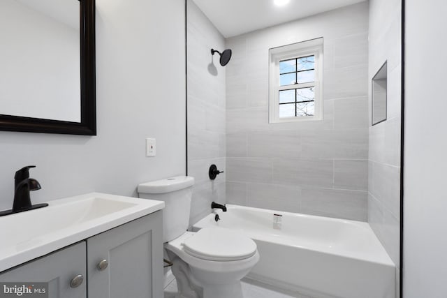 full bathroom featuring tile patterned flooring, vanity, toilet, and tiled shower / bath combo