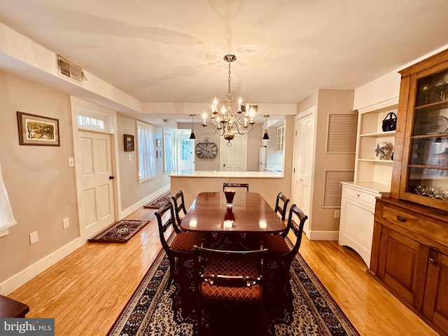 dining room with an inviting chandelier and light hardwood / wood-style flooring