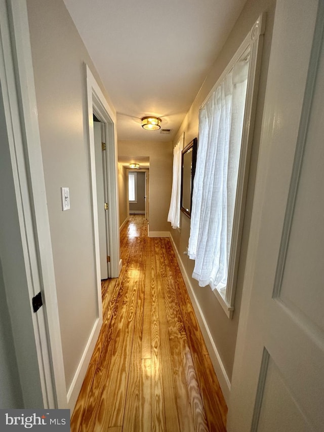 corridor with light hardwood / wood-style floors