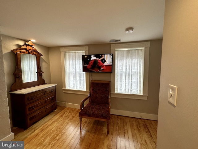 living area featuring a wealth of natural light and light hardwood / wood-style floors