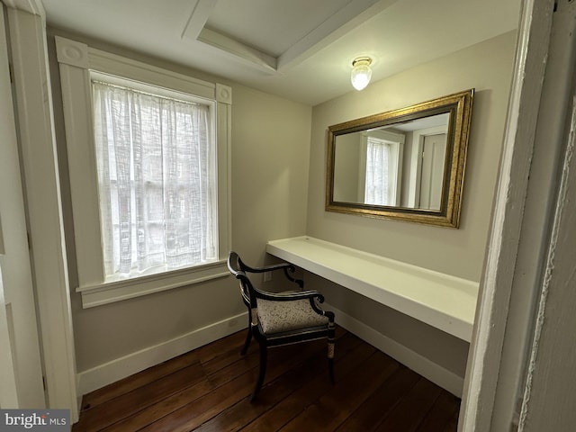 office with a healthy amount of sunlight, built in desk, and dark wood-type flooring