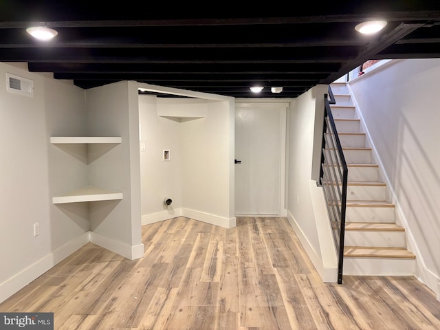 basement with light hardwood / wood-style flooring