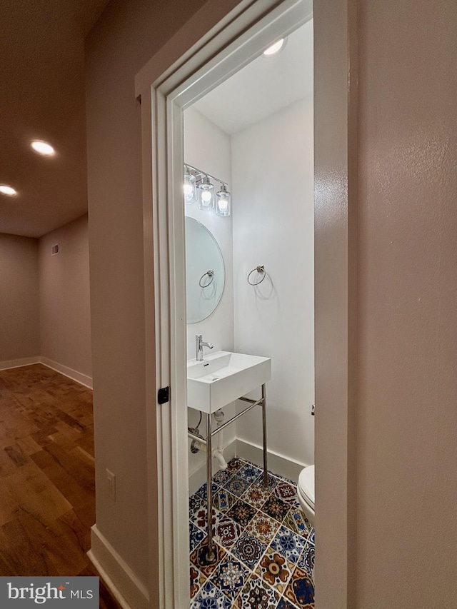 bathroom featuring hardwood / wood-style flooring, toilet, and sink