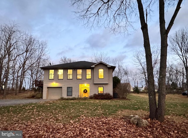 view of front of house with a garage, a deck, and a front lawn