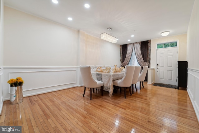 dining room with light wood-type flooring and a chandelier