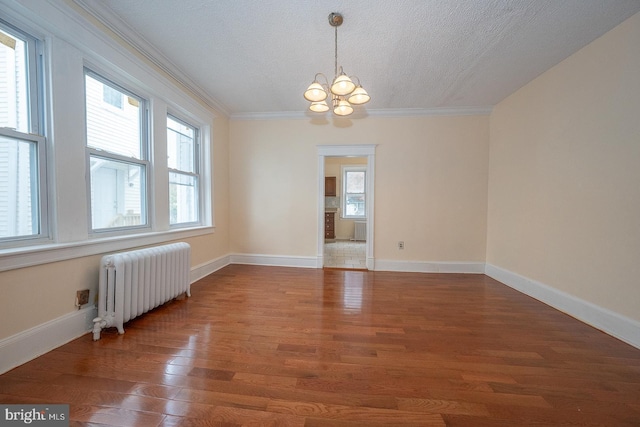 17 Elm Ave, Upper Darby, PA 19082 - spare room featuring radiator heating unit, a chandelier, healthy amount of natural light, wood finished floors, and ornamental molding