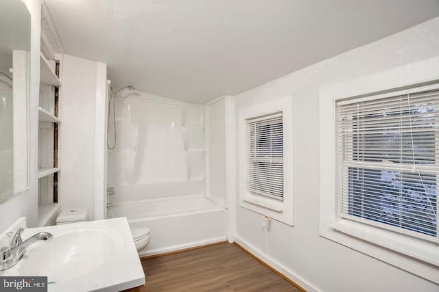 full bathroom featuring hardwood / wood-style floors, vanity,  shower combination, and toilet