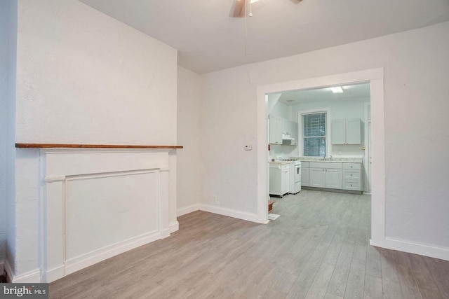 unfurnished living room featuring ceiling fan and light hardwood / wood-style flooring